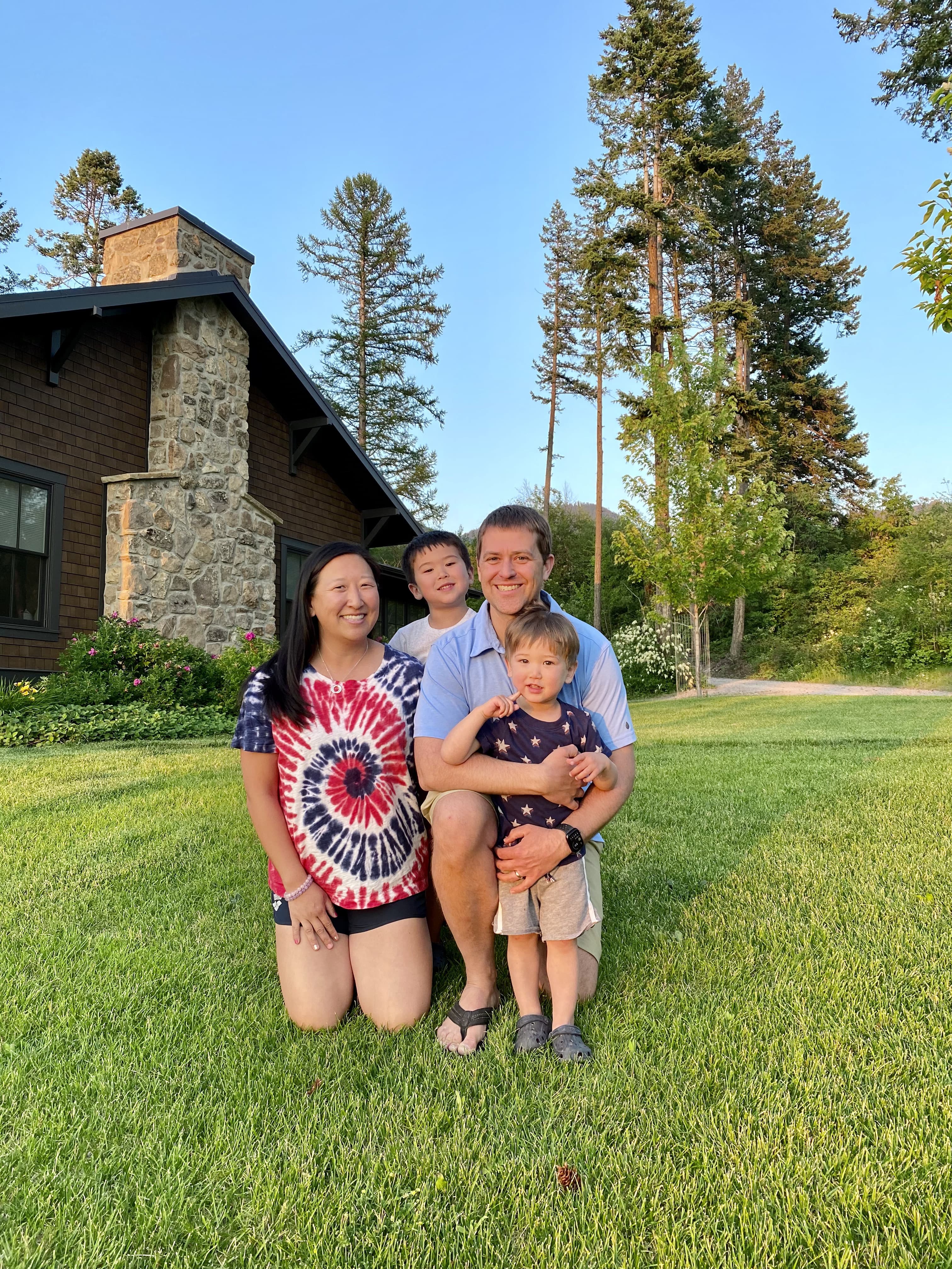Tim Cook and family in front of trees and building on grass.