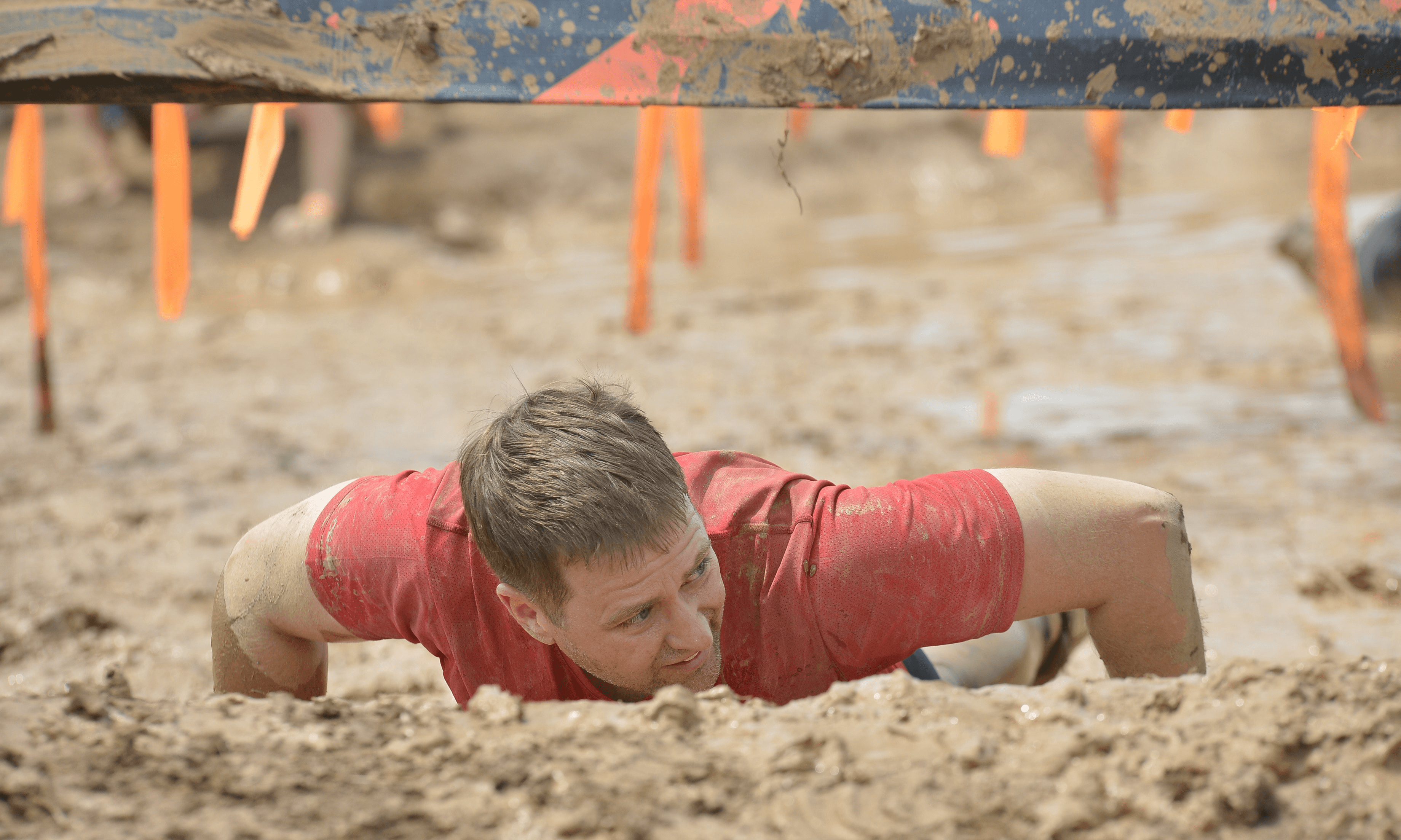 Tim cook laying down at a Touch Mudder event.